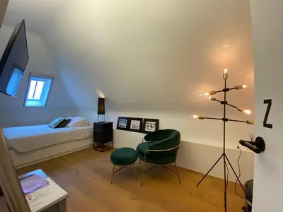 a room with a bedroom with a bed and a television at Oase d'Itegem - Wellness & Luxe in Heist-op-den-Berg