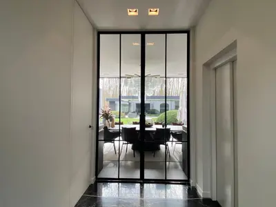 a hallway with glass doors leading to a dining room at Oase d'Itegem - Wellness & Luxe in Heist-op-den-Berg