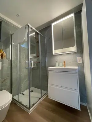 a bathroom with a shower and a sink and a toilet at Bright apartment with private parking near Ghent city centre in Ghent