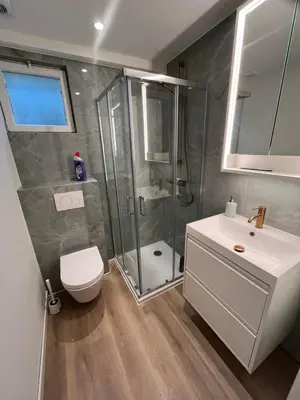 a bathroom with a shower and a toilet and a sink at Bright apartment with private parking near Ghent city centre in Ghent