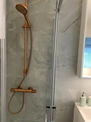a shower with a shower head in a bathroom at Bright apartment with private parking near Ghent city centre in Ghent