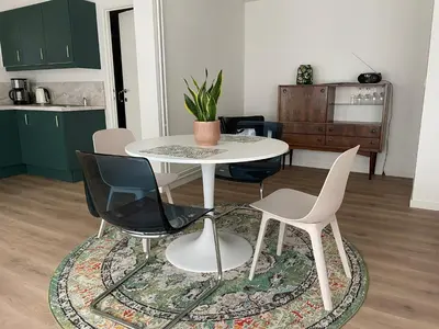 a dining room with a white table and chairs at Bright apartment with private parking near Ghent city centre in Ghent