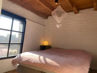 a white bedroom with a bed and a window at Cosy house 6 people in Kontich