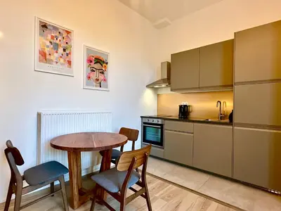 a kitchen with a table and chairs and a table and a kitchen with a refrigerator at Luxury Suites Royal by Rikas Hotels in Antwerp