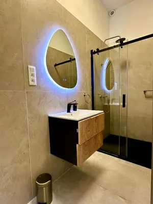 a bathroom with a sink and a mirror and a shower at Luxury Suites Royal by Rikas Hotels in Antwerp
