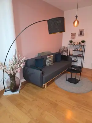 a living room with a couch and a vase with flowers at Lovely & Modern apartment in the heart of Antwerp in Antwerp