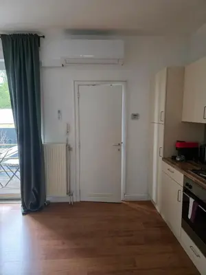 an empty kitchen with a door to a balcony at Lovely & Modern apartment in the heart of Antwerp in Antwerp