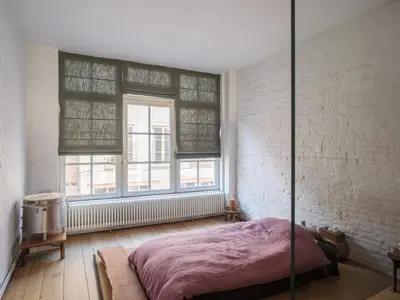 a bedroom with a bed and a brick wall at Brooklyn Five in Ghent