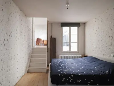 a bedroom with a bed and a white brick wall at Brooklyn Five in Ghent