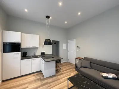 a living room with a couch and a kitchen at Midi Station in Brussels