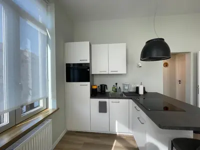 a white kitchen with white cabinets and a window at Midi Station in Brussels