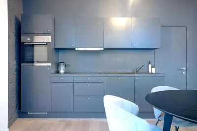 a kitchen with blue cabinets and a table with chairs at 2BR Apartment AA Location Antwerp in Antwerp