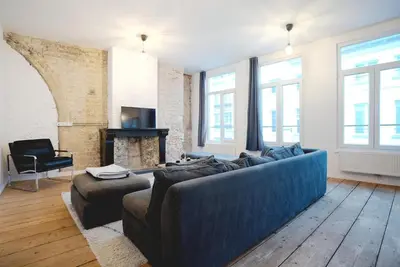 a living room with a blue couch and a fireplace at 2BR Apartment AA Location Antwerp in Antwerp