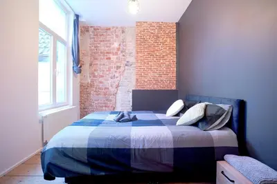 a bedroom with a bed with a brick wall at 2BR Apartment AA Location Antwerp in Antwerp