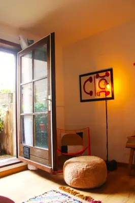 a room with a window and a ottoman next to a window at Madame Chapeau II in Brussels