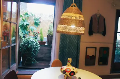 a vase sitting on a table under a lamp at Madame Chapeau II in Brussels
