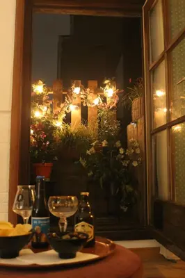 a table with wine glasses and a window with lights at Madame Chapeau II in Brussels