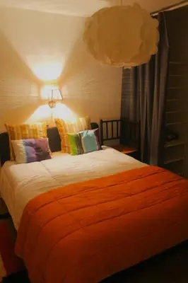 a bedroom with a large bed with an orange blanket at Madame Chapeau II in Brussels
