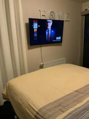 a bedroom with a bed and a tv on the wall at The Stalle in Brussels
