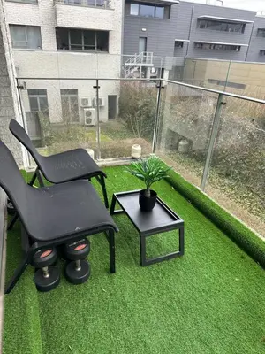 a patio with two chairs and a table and a plant at The Stalle in Brussels
