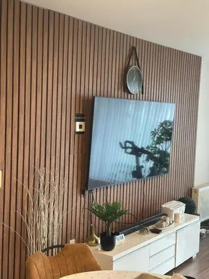 a living room with a flat screen tv on a wooden wall at The Stalle in Brussels