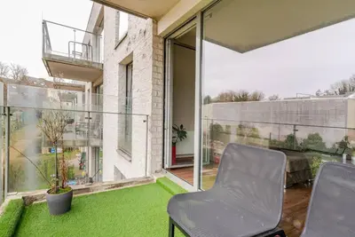 a room with a balcony with chairs and green grass at The Stalle in Brussels