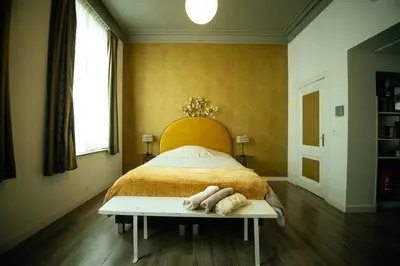 a bedroom with a bed with a wooden head board at The Cozy Guestroom near Park Zuid and Musea in Antwerp
