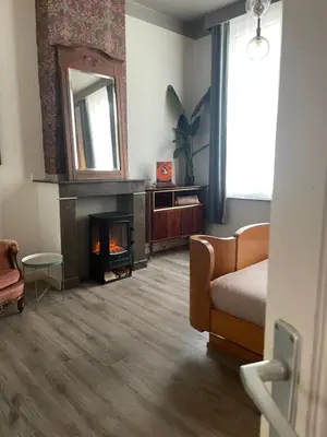 a bedroom with a fireplace and a couch and a mirror at The Art Deco Guestroom near Musea in Antwerp