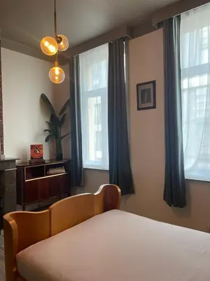 a bedroom with a bed and two windows at The Art Deco Guestroom near Musea in Antwerp