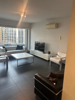 a living room with a couch and a tv at Charming central apartments with balcony views in Brussels