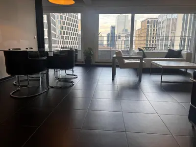 a room with a table and chairs and a large window at Charming central apartments with balcony views in Brussels