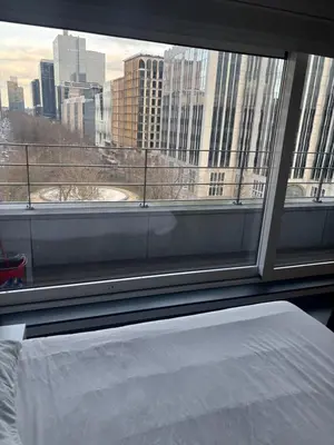 a bedroom with a view of a city from a window at Charming central apartments with balcony views in Brussels
