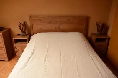 a bedroom with a white bed and two night stands at Huis van Rooi in Sint-Agatha-Rode