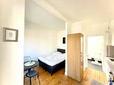 a small bedroom with a bed and a table at Beautiful & Charming studio EU DISTRICT in Brussels