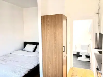 a bedroom with a bed and a door to a bathroom at Beautiful & Charming studio EU DISTRICT in Brussels