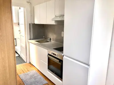 a kitchen with white cabinets and a sink and a stove at Beautiful & Charming studio EU DISTRICT in Brussels