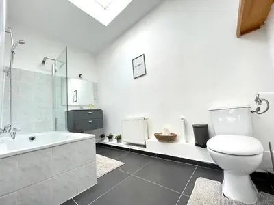 a white bathroom with a toilet and a bath tub at Beautiful & Charming studio EU DISTRICT in Brussels