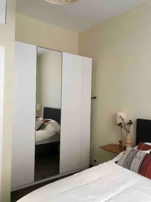 a bedroom with a mirror and a bed in it at Cosy 1 bedroom apartment in EU DISTRICT in Brussels