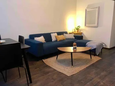 a living room with a blue couch and a table at Cosy 1 bedroom apartment in EU DISTRICT in Brussels