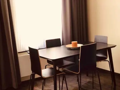 a dining room table with chairs and a candle on it at Cosy 1 bedroom apartment in EU DISTRICT in Brussels