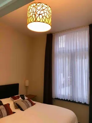 a bedroom with a bed and a large window at Cosy 1 bedroom apartment in EU DISTRICT in Brussels