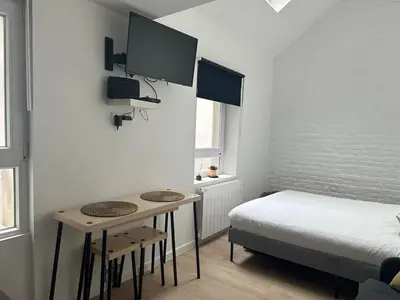 a bedroom with a bed and a table with two chairs at Ixelles - Cozy studio in middle of European District in Brussels