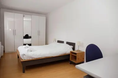 a bedroom with a bed and a desk and a table at Appartement, deux chambres au pied du métro Montgomery in Brussels
