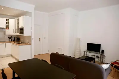 a living room with a couch and a kitchen at Appartement, deux chambres au pied du métro Montgomery in Brussels