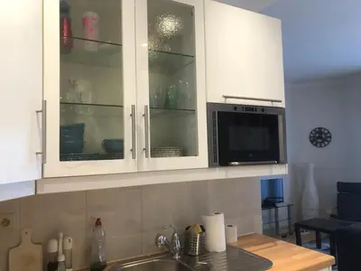 a kitchen with white cabinets and a microwave at Appartement, deux chambres au pied du métro Montgomery in Brussels