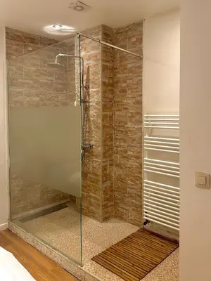 a shower with a glass door in a bathroom at ETTERBEEK - Sunny loft Studio - EU AREA in Brussels