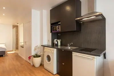a kitchen with a sink and a washing machine at ETTERBEEK - Sunny loft Studio - EU AREA in Brussels