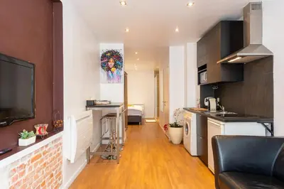 a kitchen and living room with a couch and a table at ETTERBEEK - Sunny loft Studio - EU AREA in Brussels