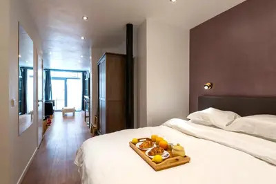 a tray of fruit on a bed in a bedroom at ETTERBEEK - Sunny loft Studio - EU AREA in Brussels