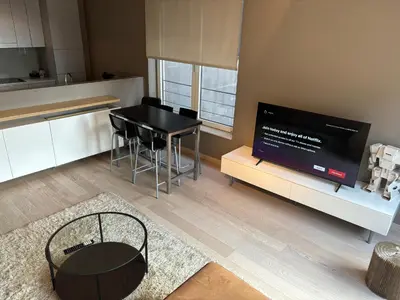 a living room with a black table and a tv at Comfortable Two bedroom Apartment in City Center in Brussels